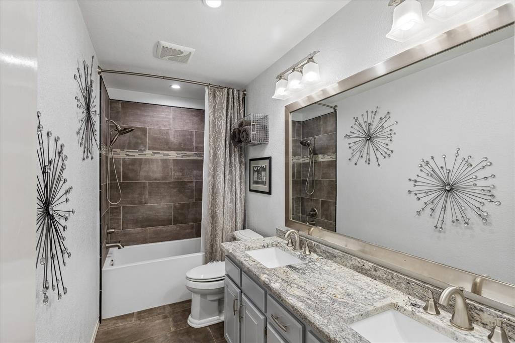 404 Moonlight Lane Keller, TX 76248 - Photo 31 of 40 a bathroom with a granite countertop sink a toilet a bathtub and shower