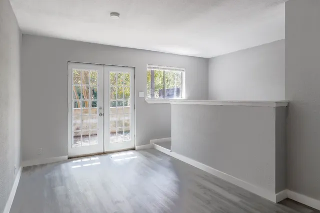 an empty room with wooden floor and windows