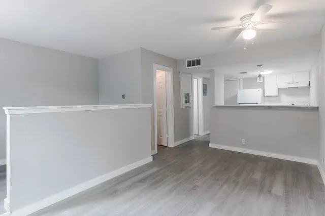 wooden floor in an empty room with a kitchen