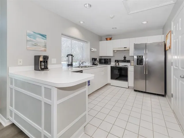 a kitchen with stainless steel appliances a refrigerator sink and microwave