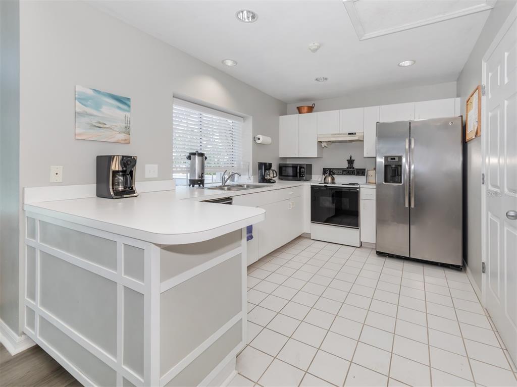 561 Clubside Circle, Unit 58 Venice, FL 34293 - Photo 32 of 44 a kitchen with stainless steel appliances a refrigerator sink and microwave