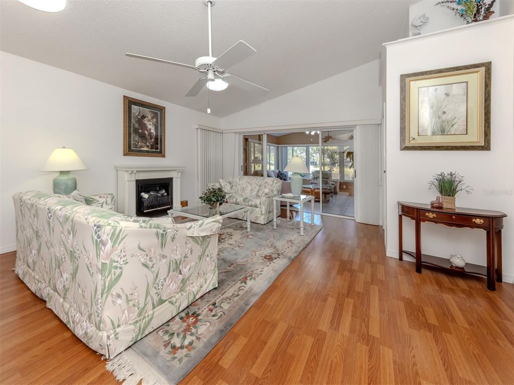 561 Clubside Circle, Unit 58 Venice, FL 34293 - Photo 5 of 44 a living room with furniture and a fireplace