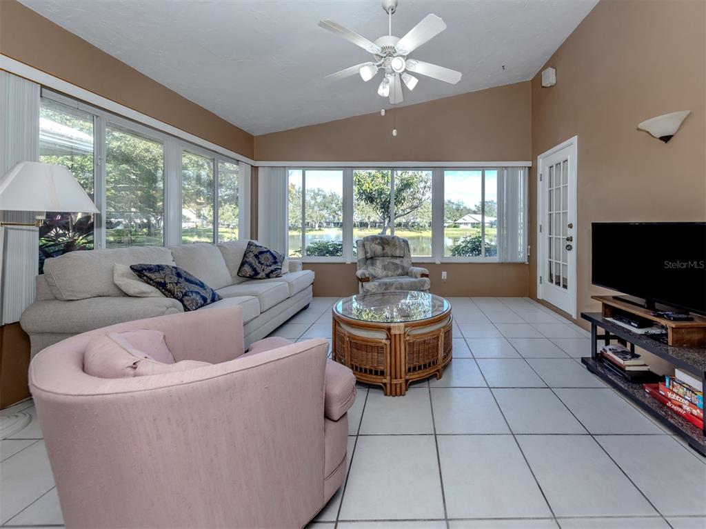 561 Clubside Circle, Unit 58 Venice, FL 34293 - Photo 10 of 44 a living room with furniture and a flat screen tv