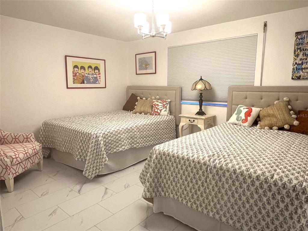 1000 Riverside Drive, Unit B104 Palmetto, FL 34221 - Photo 18 of 36 a bedroom with two beds and painting on the wall