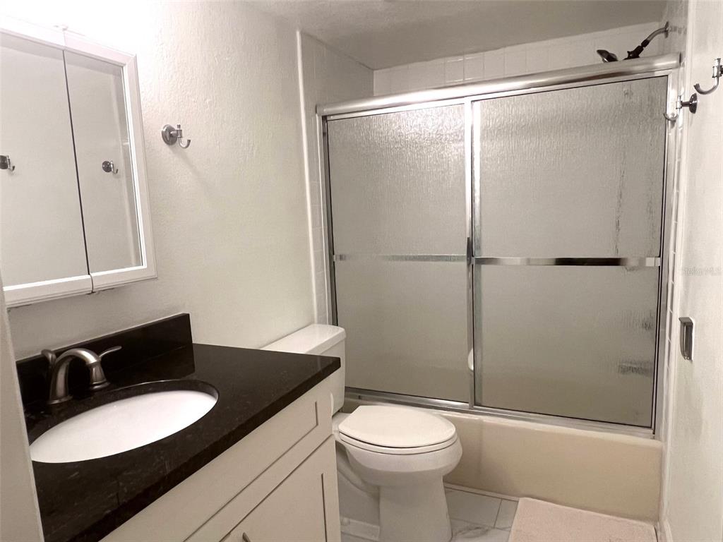 1000 Riverside Drive, Unit B104 Palmetto, FL 34221 - Photo 19 of 36 a bathroom with a granite countertop sink toilet a mirror and shower