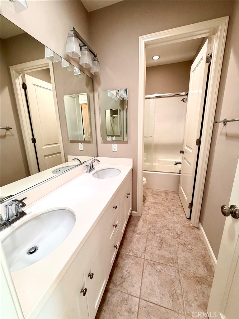 56 Strawberry Grove Irvine, CA 92620 - Photo 15 of 24 a spacious bathroom with a double vanity sink a mirror and a bathtub