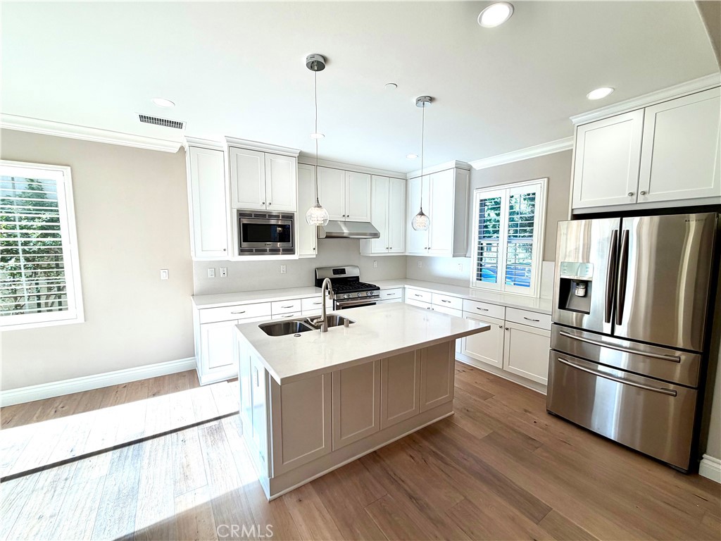 56 Strawberry Grove Irvine, CA 92620 - Photo 8 of 24 a kitchen with stainless steel appliances granite countertop a sink stove and refrigerator