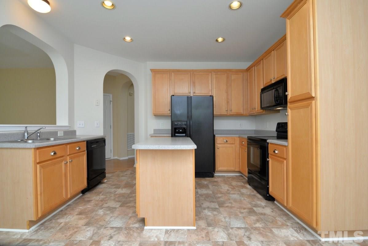 8303 Rubblestone Path Raleigh, NC 27613 - Photo 11 of 25 a kitchen with stainless steel appliances granite countertop a refrigerator a stove top oven a sink and dishwasher