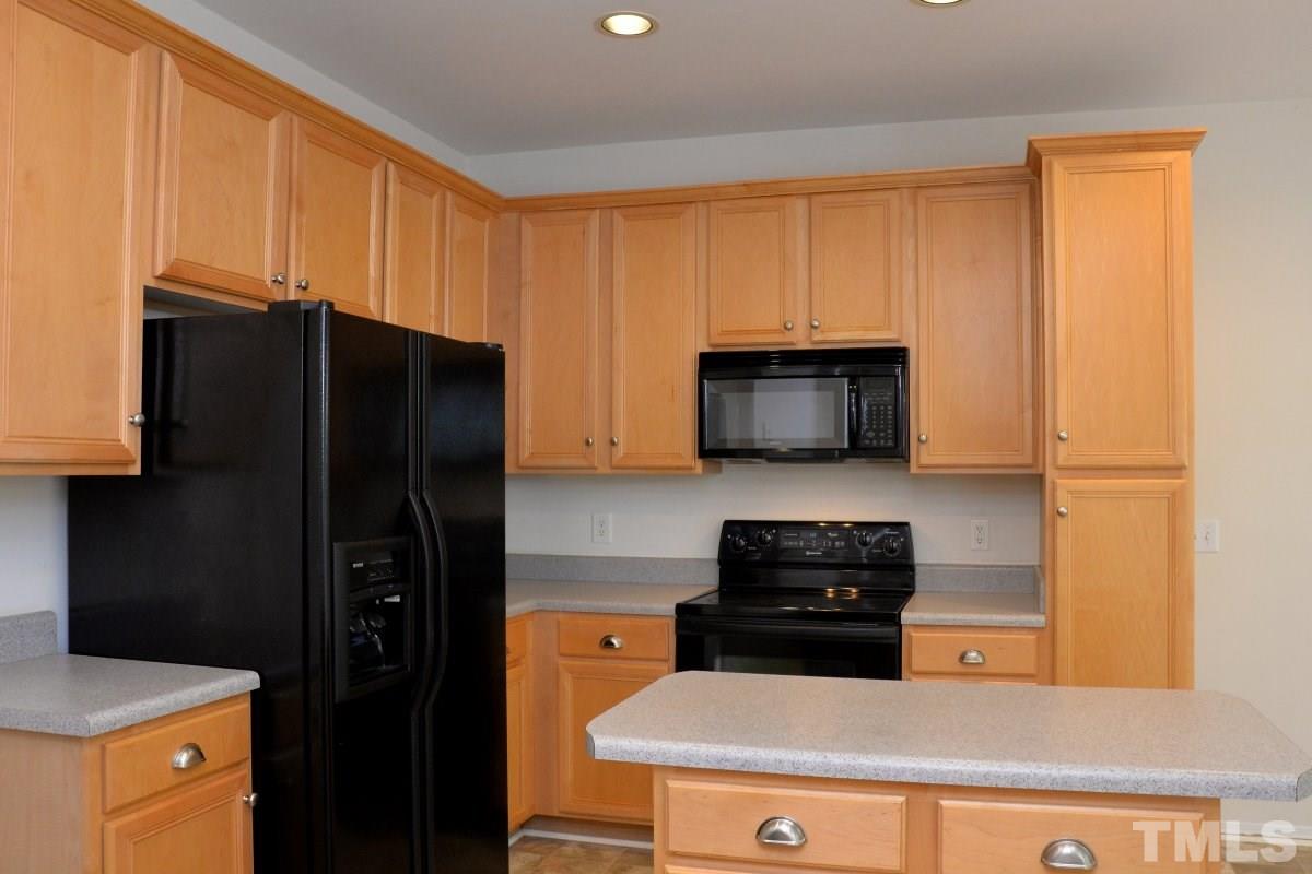 8303 Rubblestone Path Raleigh, NC 27613 - Photo 12 of 25 a kitchen with a refrigerator and a stove