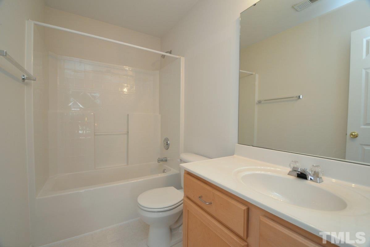 8303 Rubblestone Path Raleigh, NC 27613 - Photo 22 of 25 a bathroom with a granite countertop sink toilet and shower