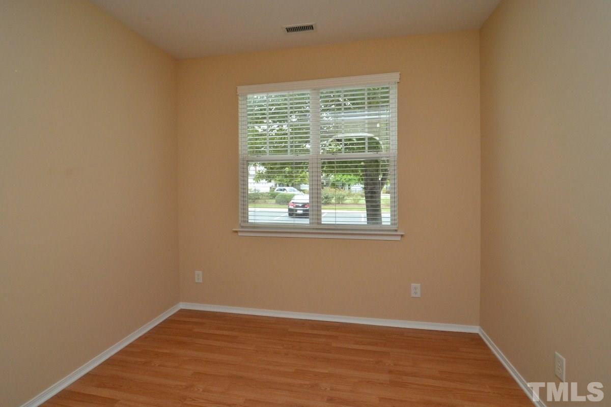 8303 Rubblestone Path Raleigh, NC 27613 - Photo 8 of 25 an empty room with wooden floor and windows