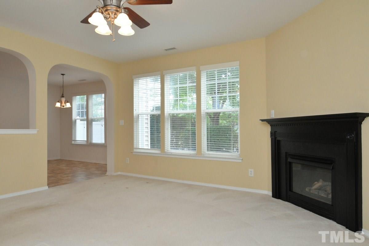 8303 Rubblestone Path Raleigh, NC 27613 - Photo 10 of 25 a view of an empty room with a fireplace and a window