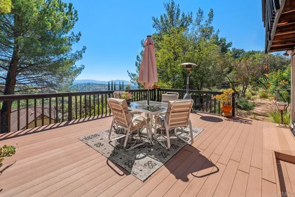a view of a patio with dining table and chairs with wooden floor