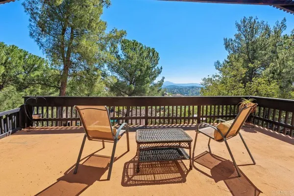 a view of a chairs and table on wooden deck