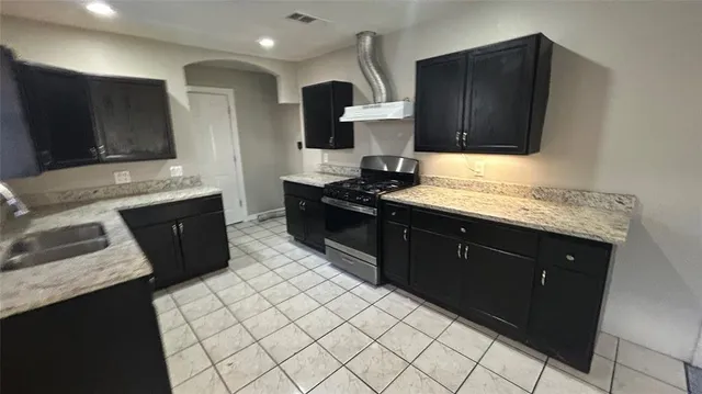 a kitchen with stainless steel appliances granite countertop a sink stove and microwave