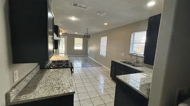 a large bathroom with a granite countertop sink a toilet and a bathtub