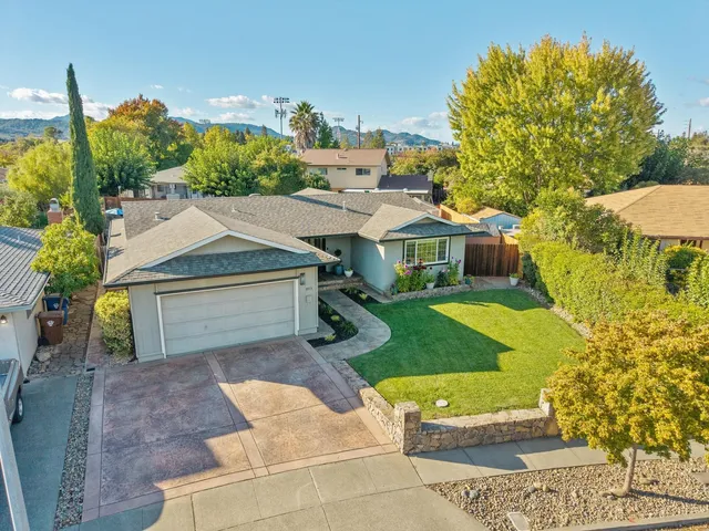 a aerial view of a house with a yard and potted plants