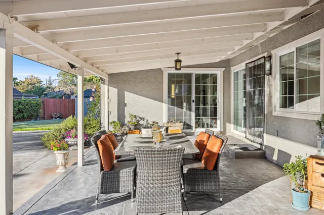 a view of a patio with table and chairs potted plants and large tree
