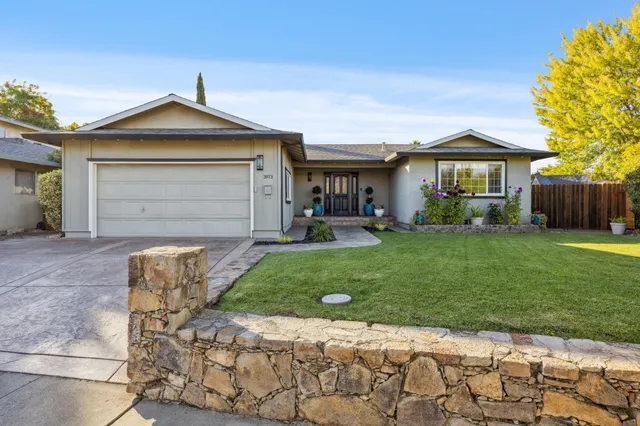 a view of a house with potted plants and a bench