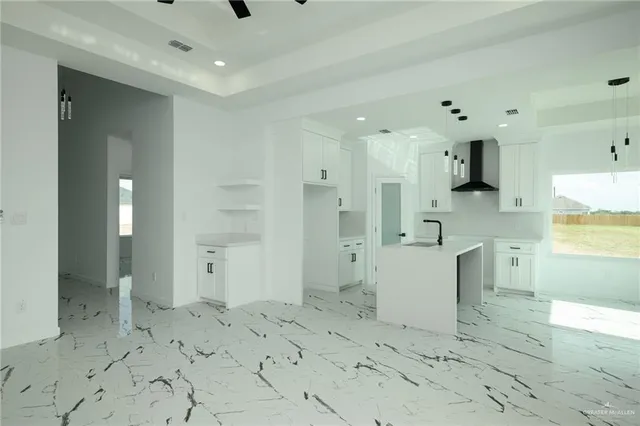 a large white kitchen with a stove a sink dishwasher and a refrigerator