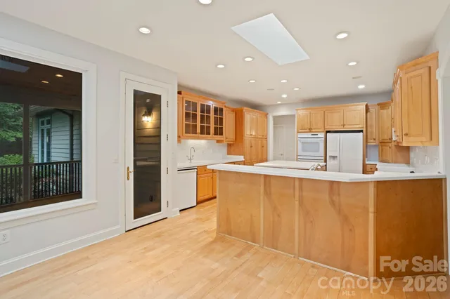 a large kitchen with stainless steel appliances a large counter top a stove and a refrigerator