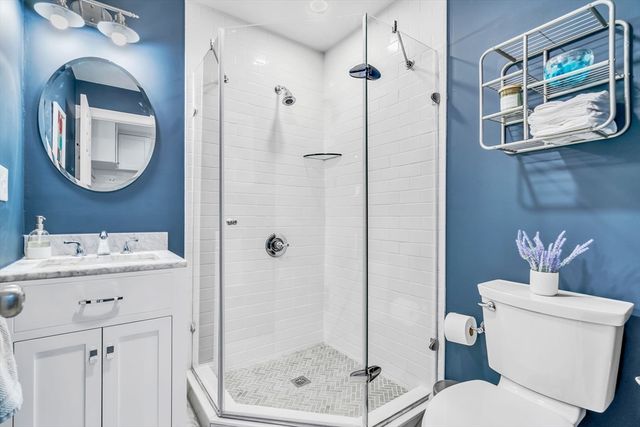 a bathroom with a toilet sink vanity and mirror