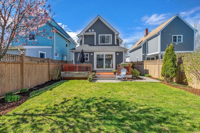a view of a house with a yard and deck area