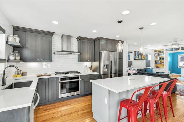 a kitchen with stainless steel appliances a sink a stove a refrigerator cabinets and a center island