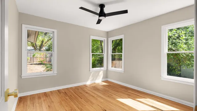 a view of empty room with window and ceiling fan
