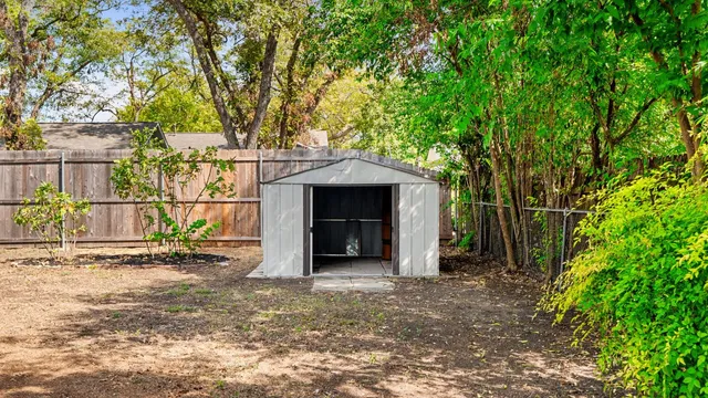 a view of a house with a small yard and tree