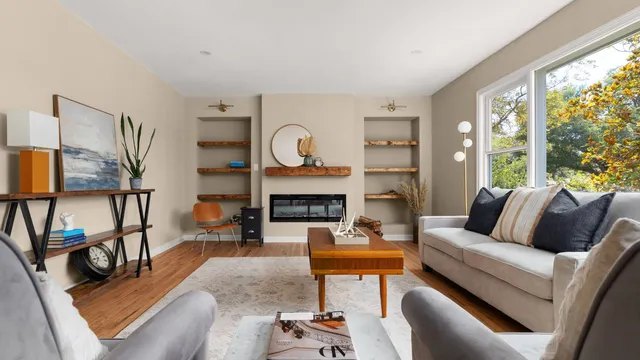 a living room with furniture a fireplace and a large window
