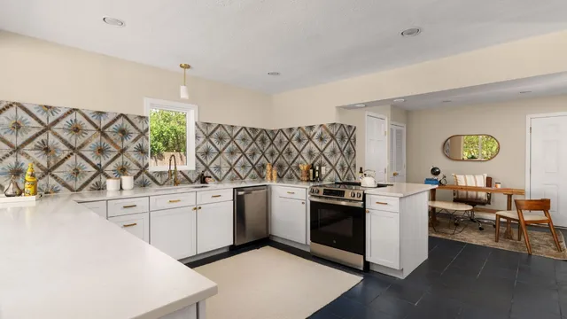 a kitchen with stainless steel appliances granite countertop a stove a sink and a refrigerator