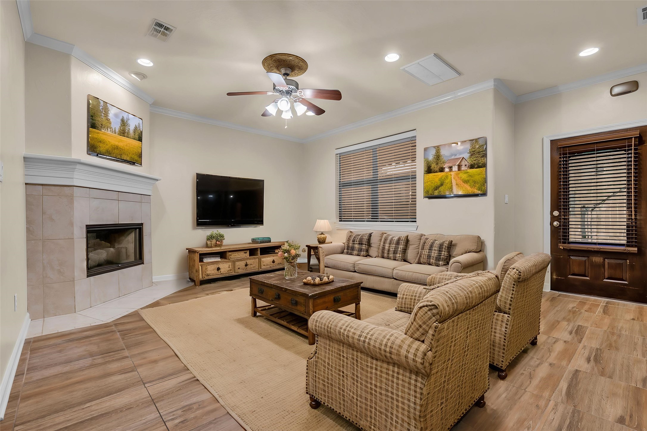 1898 Longmire Road, Unit 5 Conroe, TX 77304 - Photo 3 of 48 This virtually staged living room exudes warmth and style with its cozy fireplace, elegant wood flooring, and inviting seating area, perfect for relaxation and entertainment.