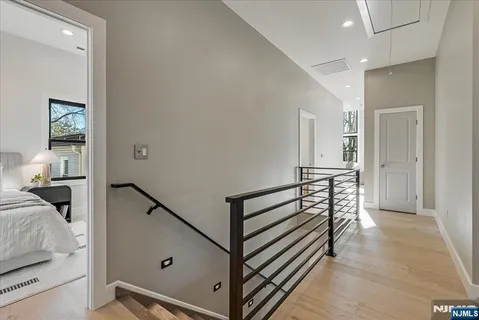 a view of a hallway with bedroom and wooden floor