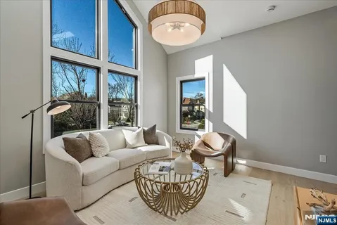 a living room with furniture a table and a large window