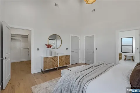 a bedroom with a bed a mirror and lamp on desk