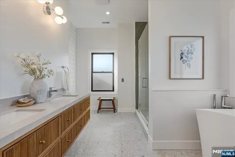 a bathroom with a double vanity sink a mirror and a bathtub