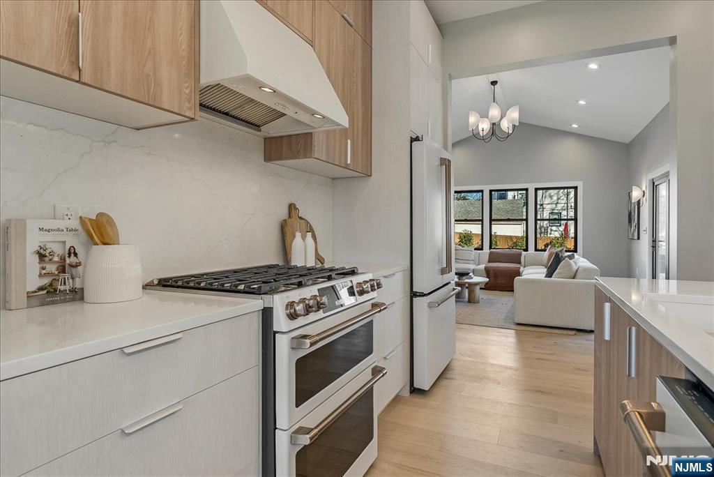 36 James Street Montclair, NJ 07042 - Photo 7 of 48 a kitchen with stainless steel appliances granite countertop a stove and white cabinets with wooden floor