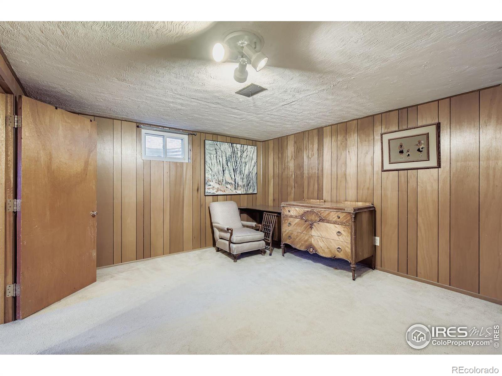 2431 West 24th Street Greeley, CO 80634 - Photo 25 of 32 a bedroom with a bed and a chandelier