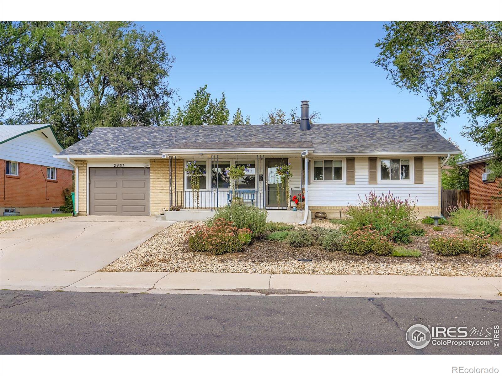 2431 West 24th Street Greeley, CO 80634 - Photo 31 of 32 a front view of a house with a yard and potted plants
