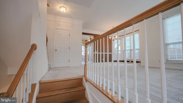 a view of staircase with lots of frames on wall and a window