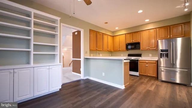 a kitchen with a refrigerator and a stove top oven