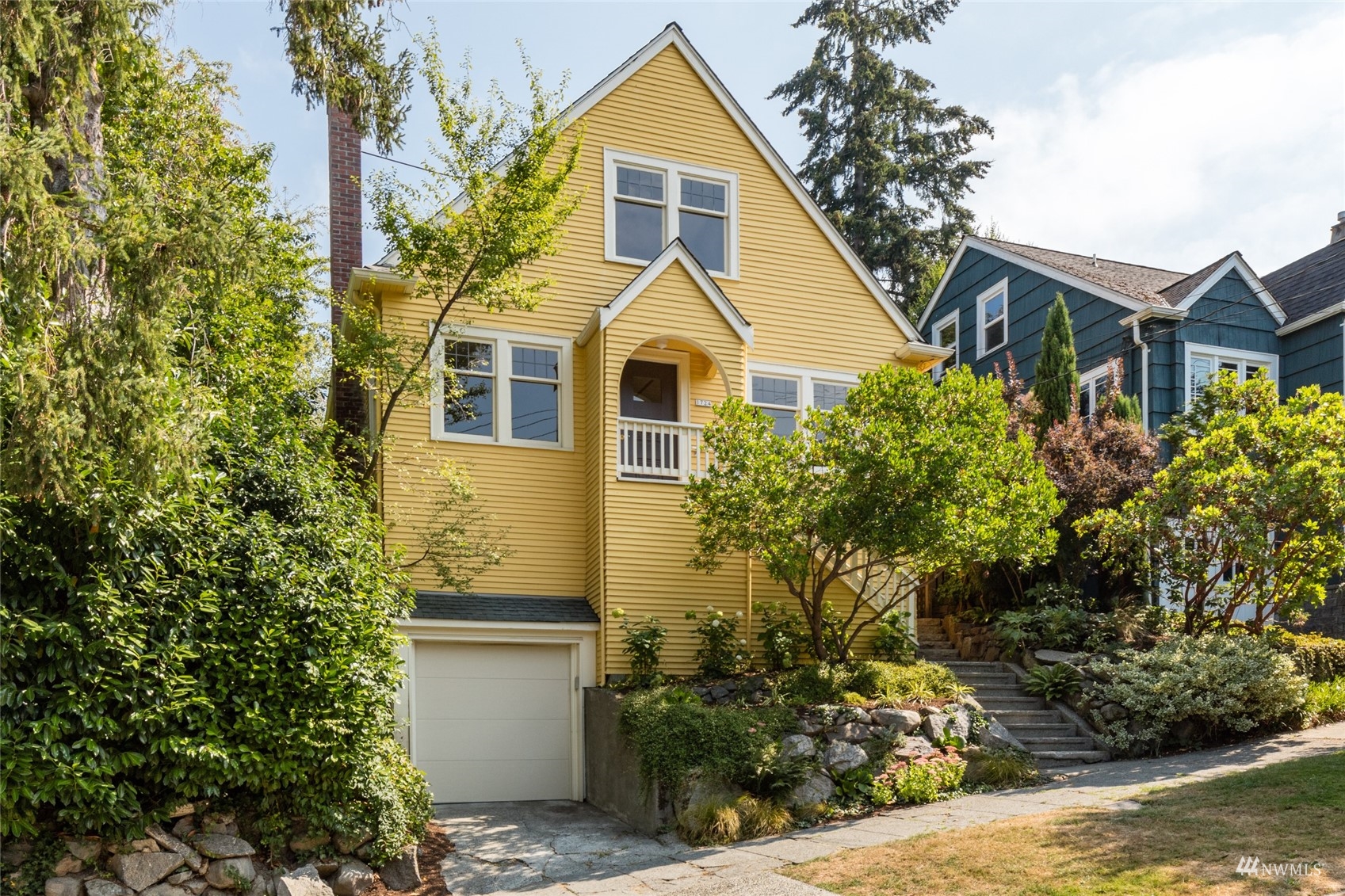 a front view of a house with a yard garage and outdoor seating