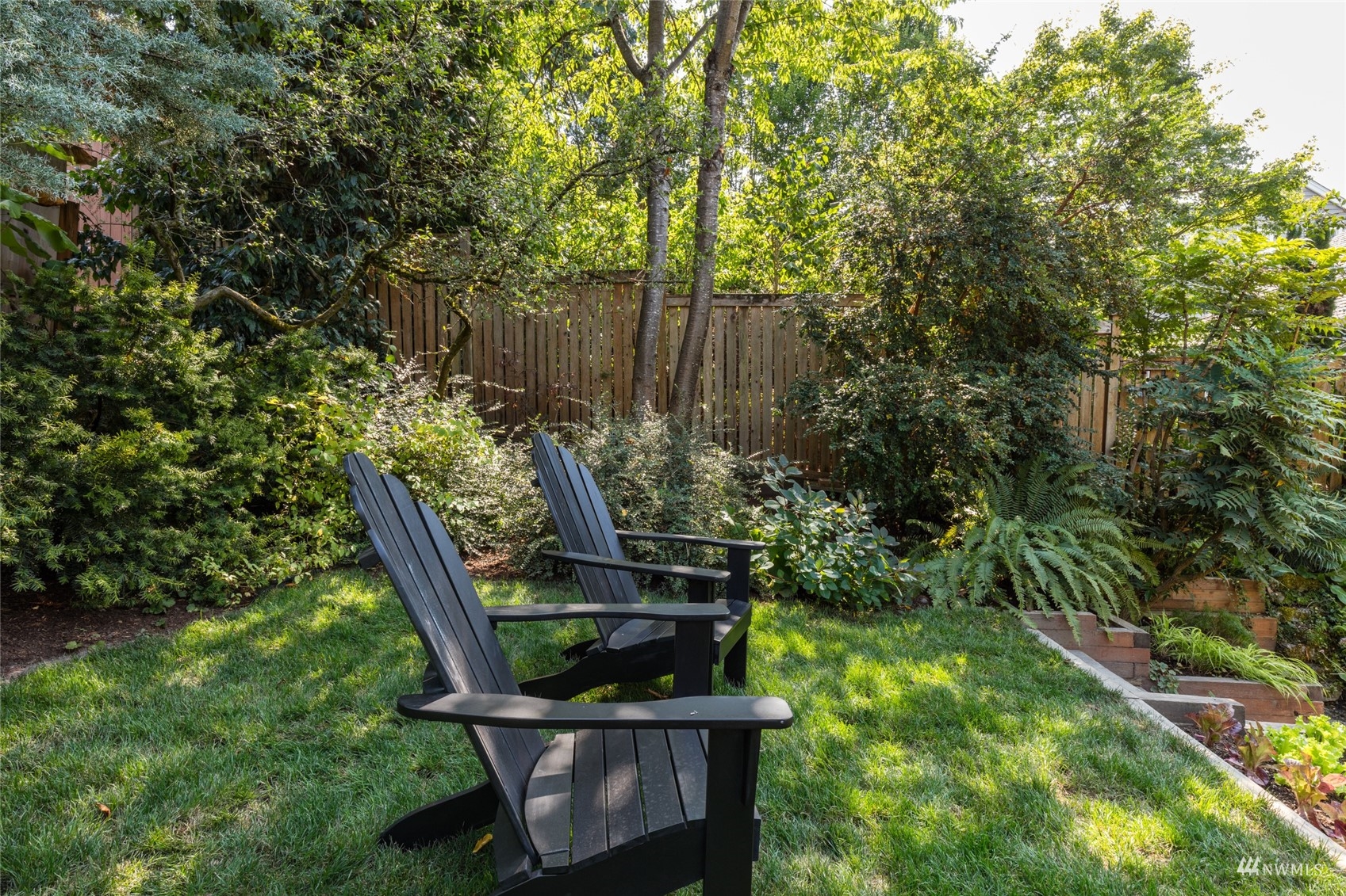 1724 31st Avenue Seattle, WA 98122 - Photo 15 of 34 a view of a backyard with plants and a bench
