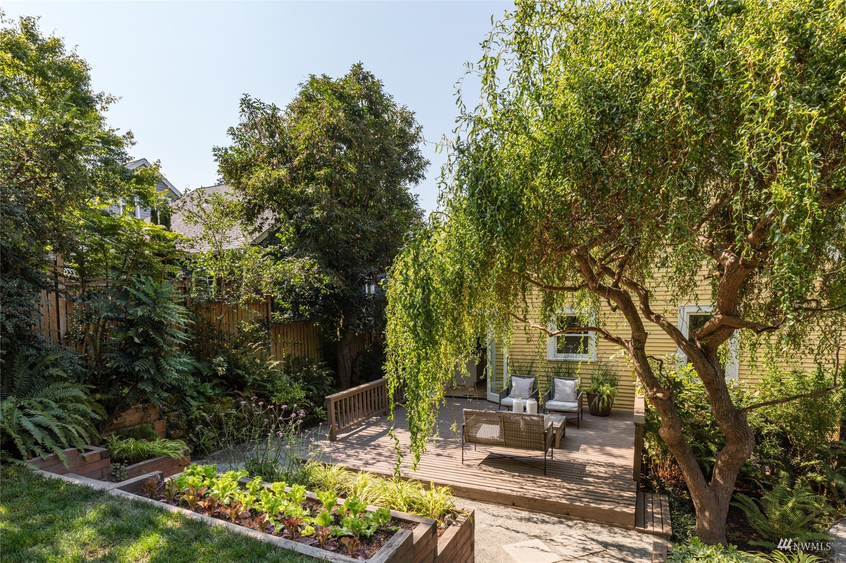 1724 31st Avenue Seattle, WA 98122 - Photo 20 of 34 a view of a patio with table and chairs with wooden fence and plants