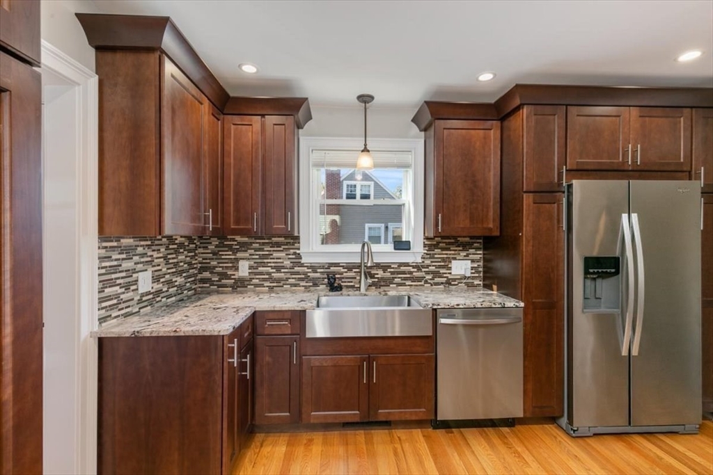 17 Old Essex Road Manchester, MA 01944 - Photo 11 of 40 a kitchen with kitchen island granite countertop wooden cabinets and a refrigerator