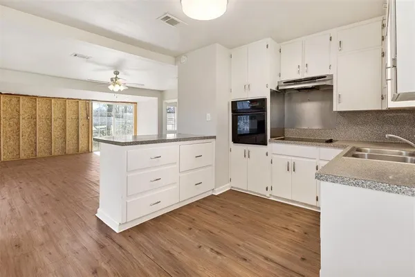 a kitchen with granite countertop white cabinets and stainless steel appliances