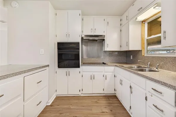 a kitchen with granite countertop white cabinets and white appliances