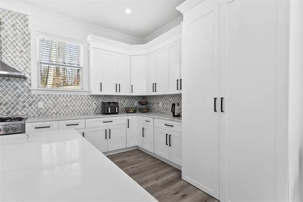 a kitchen with granite countertop white cabinets and white appliances