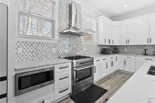 a kitchen with granite countertop white cabinets and white appliances